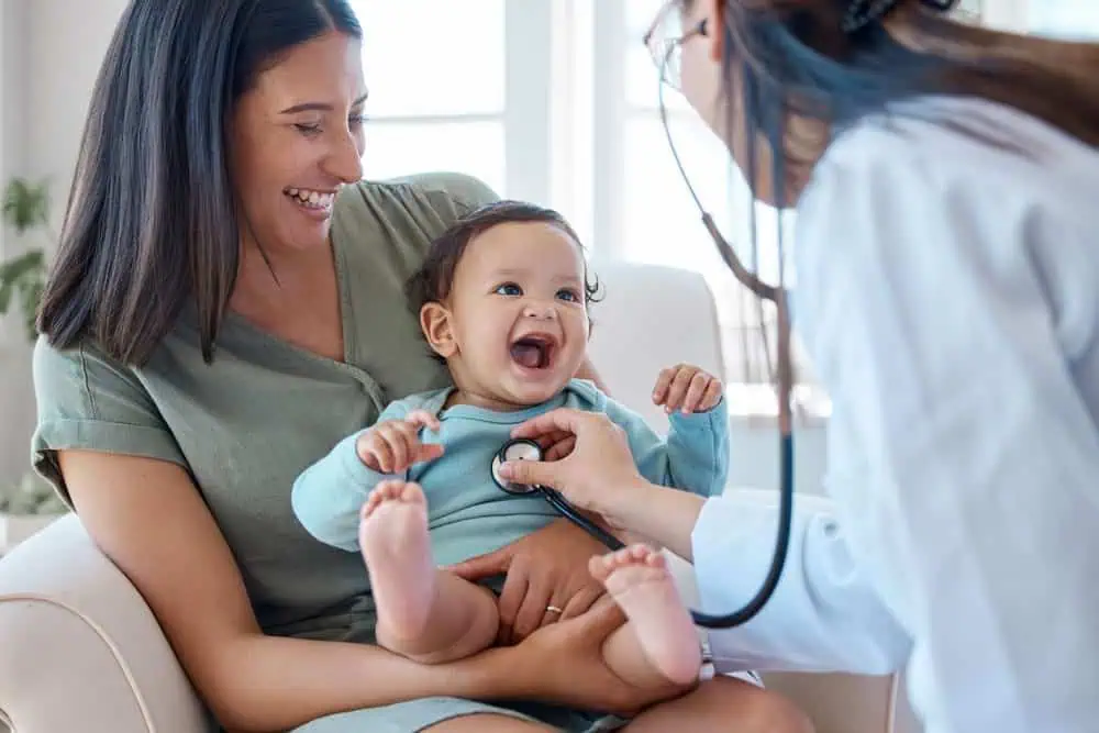 A mother holding her baby as the doctor does a checkup