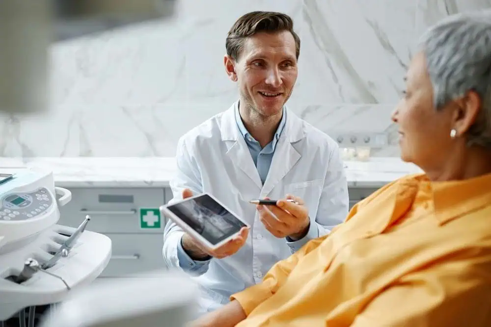 Dentist showing x-ray results to an elderly woman